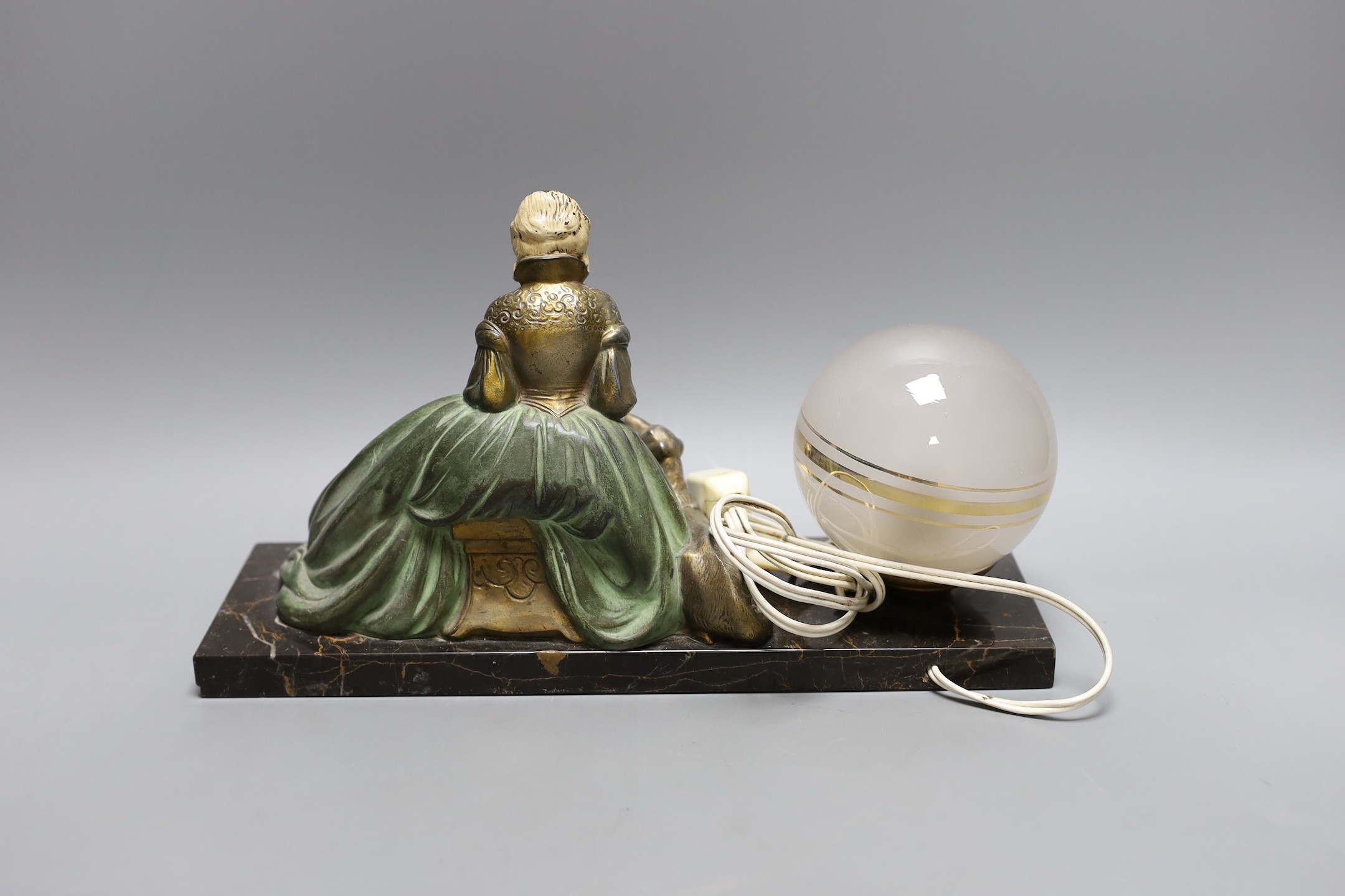 A French 1930's lamp with a seated female reading beside a laying loyal hound on marble plinth base, signed R. Miandres, 32cm wide